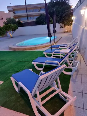 a row of lounge chairs with umbrellas next to a pool at Solar da Rosa & Solar da Tirosa in Boliqueime