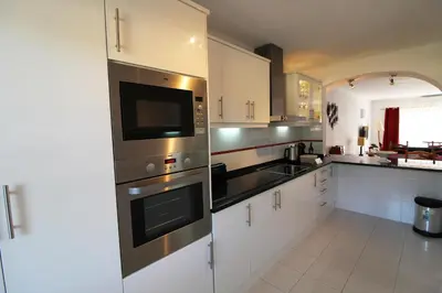 a kitchen with stainless steel appliances and white cabinets at Apt T2 Praia São Rafael Hibiscus 18A - Albufeira, Algarve in Albufeira