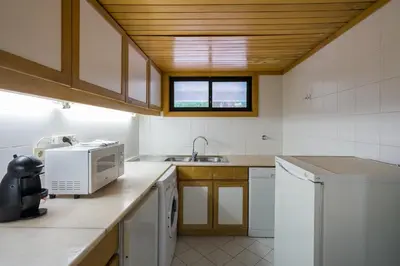 a kitchen with a microwave and a sink at BmyGuest - Quinta do Lago Garden Apartment in Almancil