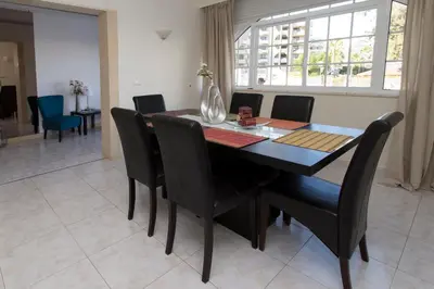 a dining room with a black table and chairs at Boas-Vindas in Albufeira
