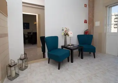 a waiting room with blue chairs and a table at Boas-Vindas in Albufeira