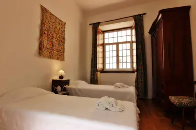a bedroom with two beds and a window at Casa dos Tios in Albufeira
