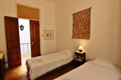a bedroom with two beds and a window and a door at Casa dos Tios in Albufeira