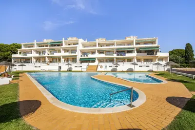 a large building with a swimming pool in front of it at Vilamoura - Cozy and Quiet Holiday Apartment in Vilamoura