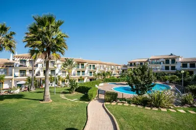 a resort with a swimming pool and palm trees at Decor n' cozy place for families and friends in Guia