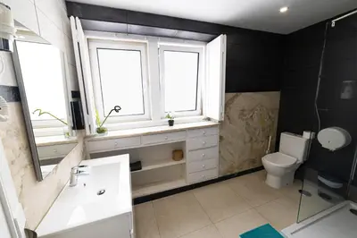 a bathroom with a sink and a toilet and windows at Greenth Avenue in Faro