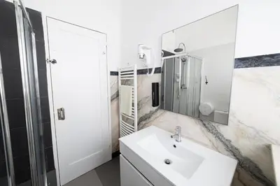 a white bathroom with a sink and a mirror at Greenth Avenue in Faro