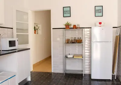 a kitchen with a white refrigerator in a room at Greenth Avenue in Faro