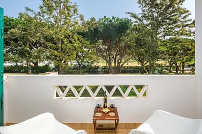 a white wall with two chairs and a table at Falésia Beach Villa by The Portuguese Butler in Olhos de Água