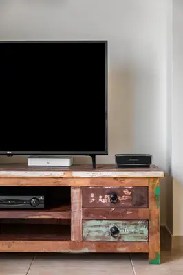 a flat screen tv sitting on top of a wooden entertainment center at Epic Falésia Apartment by The Portuguese Butler in Olhos de Água