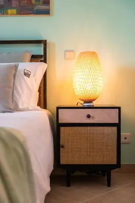 a lamp on a night stand next to a bed at Epic Falésia Apartment by The Portuguese Butler in Olhos de Água
