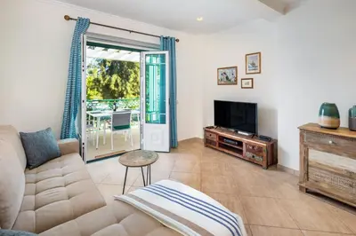 a living room with a couch and a tv at Epic Falésia Apartment by The Portuguese Butler in Olhos de Água