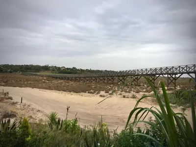 a bridge over a river with a sandy beach at Victory Village Sea Views in Quinta do Lago