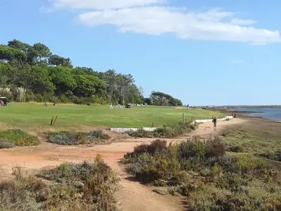 a view of a golf course with people walking along a dirt road at Victory Village Sea Views in Quinta do Lago