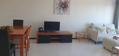 a living room with a tv and a table and a couch at Penthouse with panoramic view in Vilamoura