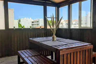a wooden table with a plant in a vase on a balcony at Albufeira Center Old Town, 8ppl, 5min Fishermans beach in Albufeira