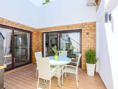 a patio with a table and chairs on a balcony at Luxury Apartment, 3 min Walk to Beach, Albufeira in Guia