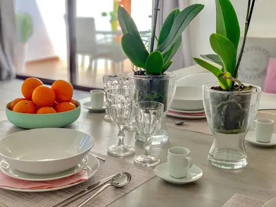 a table with plates and bowls of oranges and glasses at Luxury Apartment, 3 min Walk to Beach, Albufeira in Guia