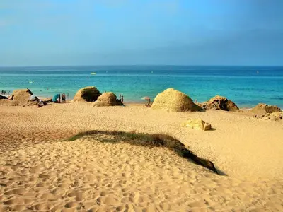 a sandy beach with rocks and the ocean at Luxury Apartment, 3 min Walk to Beach, Albufeira in Guia
