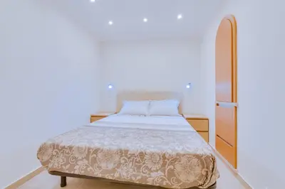 a white bedroom with a bed and a dresser at Tália IV - City Center - Vilamoura in Vilamoura