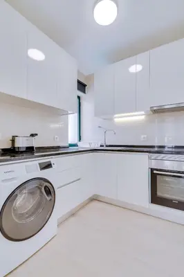a white kitchen with a washing machine in it at Tália IV - City Center - Vilamoura in Vilamoura