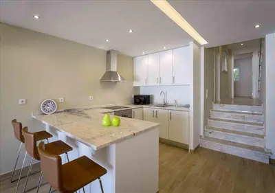 a kitchen with a island with chairs and a counter top at Vicky Rae Beach House - Vale do Lobo in Almancil
