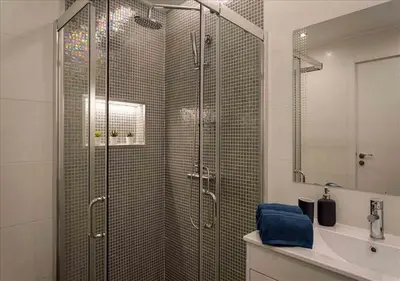 a bathroom with a shower with a glass door at Vicky Rae Beach House - Vale do Lobo in Almancil