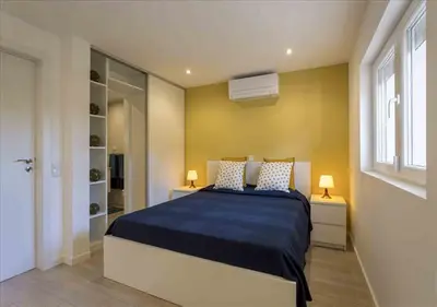 a bedroom with a large bed with a blue blanket at Vicky Rae Beach House - Vale do Lobo in Almancil