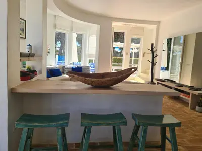a kitchen with a counter with three green stools at Villa Azul - Clever Details, Luxury villa, private pool, access to a club with tennis court, playground, communal pools in Vilamoura