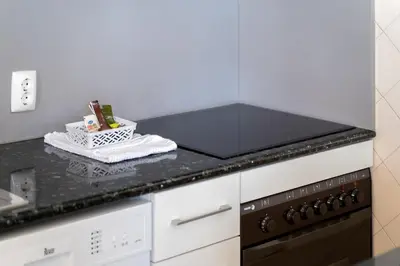 a kitchen with a black counter top with a stove at AL - R&R Vilamoura Flat, City Center in Vilamoura