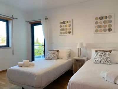 two beds in a room with white walls and windows at Penthouse 160sqm wide Terraces Pool view & private Hot Tub & Parking in Albufeira