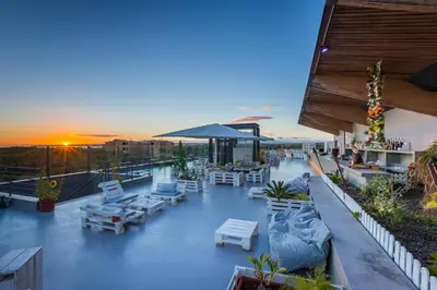a rooftop patio with chairs and tables on a building at Apartamentos Vila das Lagoas – Salgados in Guia