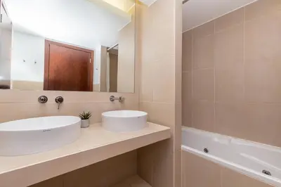 a bathroom with a sink and a mirror and a tub at Apartamentos Vila das Lagoas – Salgados in Guia