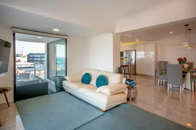 a living room with a white couch and a dining room at Infinito penthouse Luxury Best terrace Albufeira in Albufeira