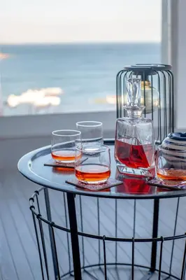 a tray with four glasses of whiskey on a table at Infinito penthouse Luxury Best terrace Albufeira in Albufeira