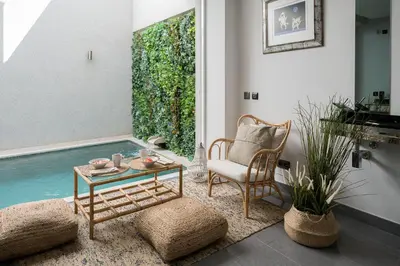 a living room with a table and a chair and water at Downtown Pool House in Faro