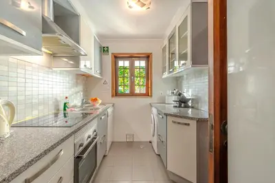 a kitchen with white counter tops and a window at T2 Casa Albufeira - Pool & Sun Terrace in Albufeira
