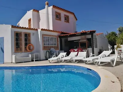 a villa with a swimming pool in front of a house at Oura Villa V5 in Albufeira
