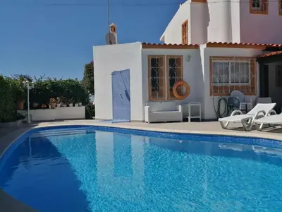 a swimming pool in front of a house at Oura Villa V5 in Albufeira