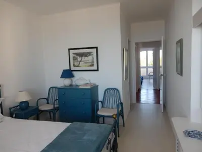 a bedroom with a bed and chairs and a blue dresser at Dreamly Sea in Albufeira