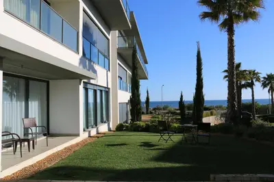 a building with a yard with chairs and a table at Cavalo Preto Luxury Beach Resort in Quarteira