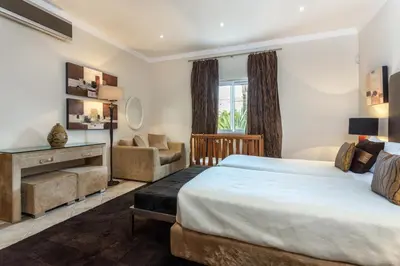 a hotel room with a bed and a chair at Villa Maureena - Quinta do Mar in Almancil