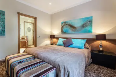 a bedroom with a large bed with blue pillows at Villa Maureena - Quinta do Mar in Almancil