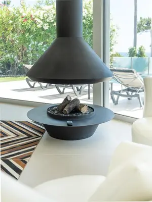 a black pendant light hanging over a fire pit at Villa Croesa - Vale de Lobo in Almancil