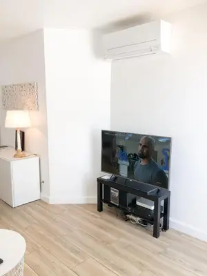 a living room with a flat screen tv and a table at Vilamoura Marina Apartment with swimming pool in Vilamoura