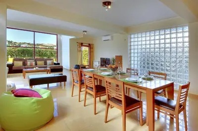 a dining room with a table and chairs and a couch at Vila Marina -BBQ, pool & garden- by Seareen in Albufeira