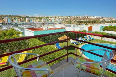 a balcony with two chairs and a swimming pool at Vila Marina -BBQ, pool & garden- by Seareen in Albufeira
