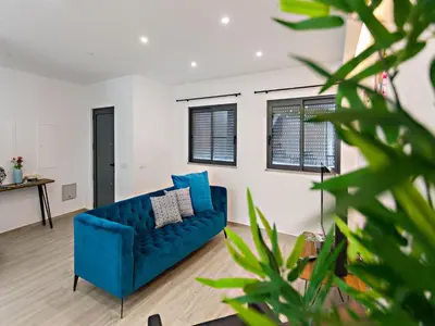 a living room with a blue couch and windows at Faro Clara Suites in Faro
