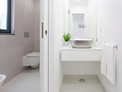 a white bathroom with a sink and a toilet at Faro Clara Suites in Faro