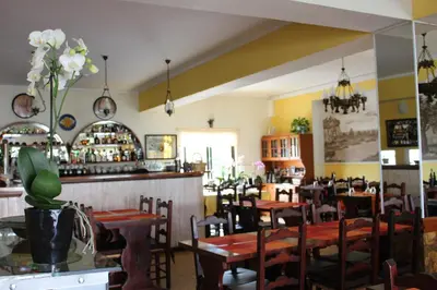 a restaurant with tables and chairs and a bar at Sunshine in Albufeira